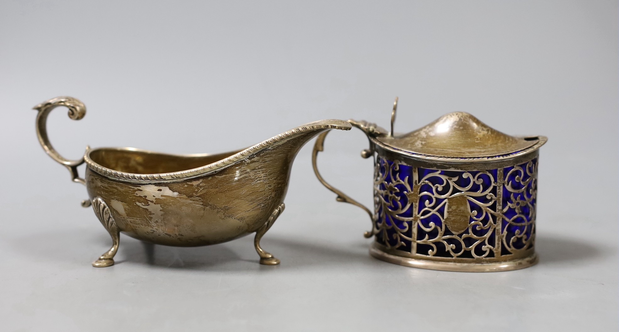 A late Victorian silver mustard, London, 1899 and a later silver sauceboat.